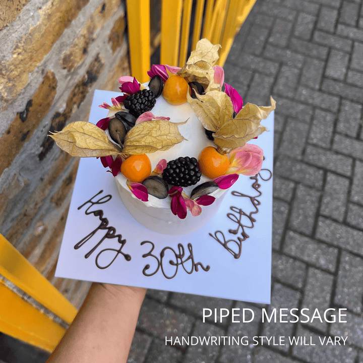 Birthday cake with piped '30th Birthday' message, physalis and blackberries